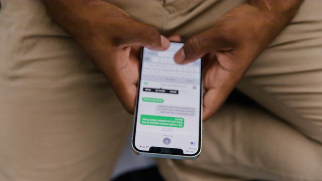 Hands typing a reply in a messaging app on a smartphone
