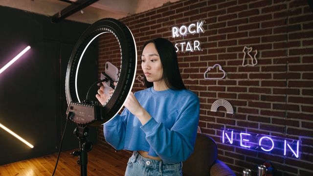 Creator filming content on a smartphone mounted in a ring light