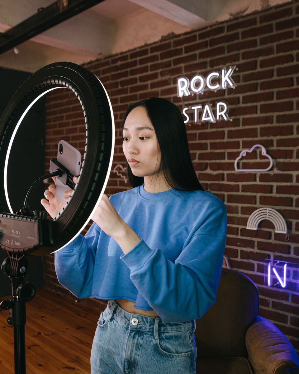 Creator filming content on a smartphone mounted in a ring light
