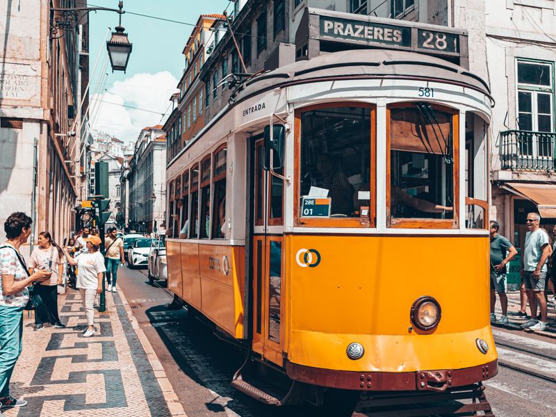 Yellow tram 28 on a sunny street in Lisbon